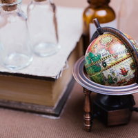 地球儀と古書が並ぶアンティーク棚の写真