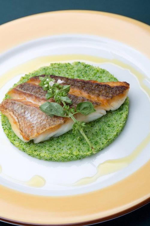 緑のソースに載せた真鯛のロースト2枚と葉飾り