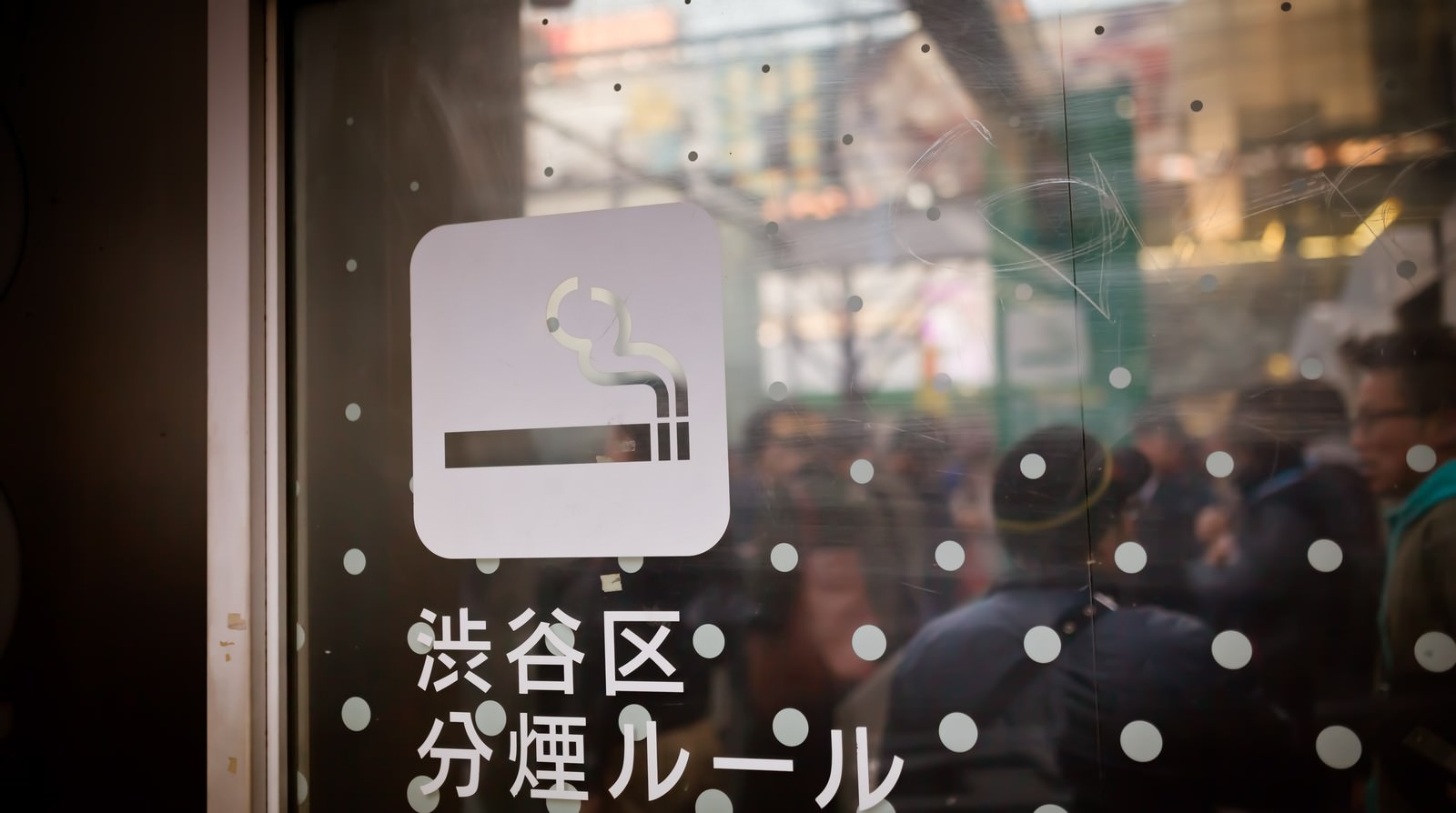 ガラス窓にたばこアイコンと渋谷区分煙ルールと書かれたステッカーが貼られている