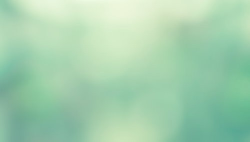 緑と黄色がぼけて混じり合う柔らかい抽象的な光