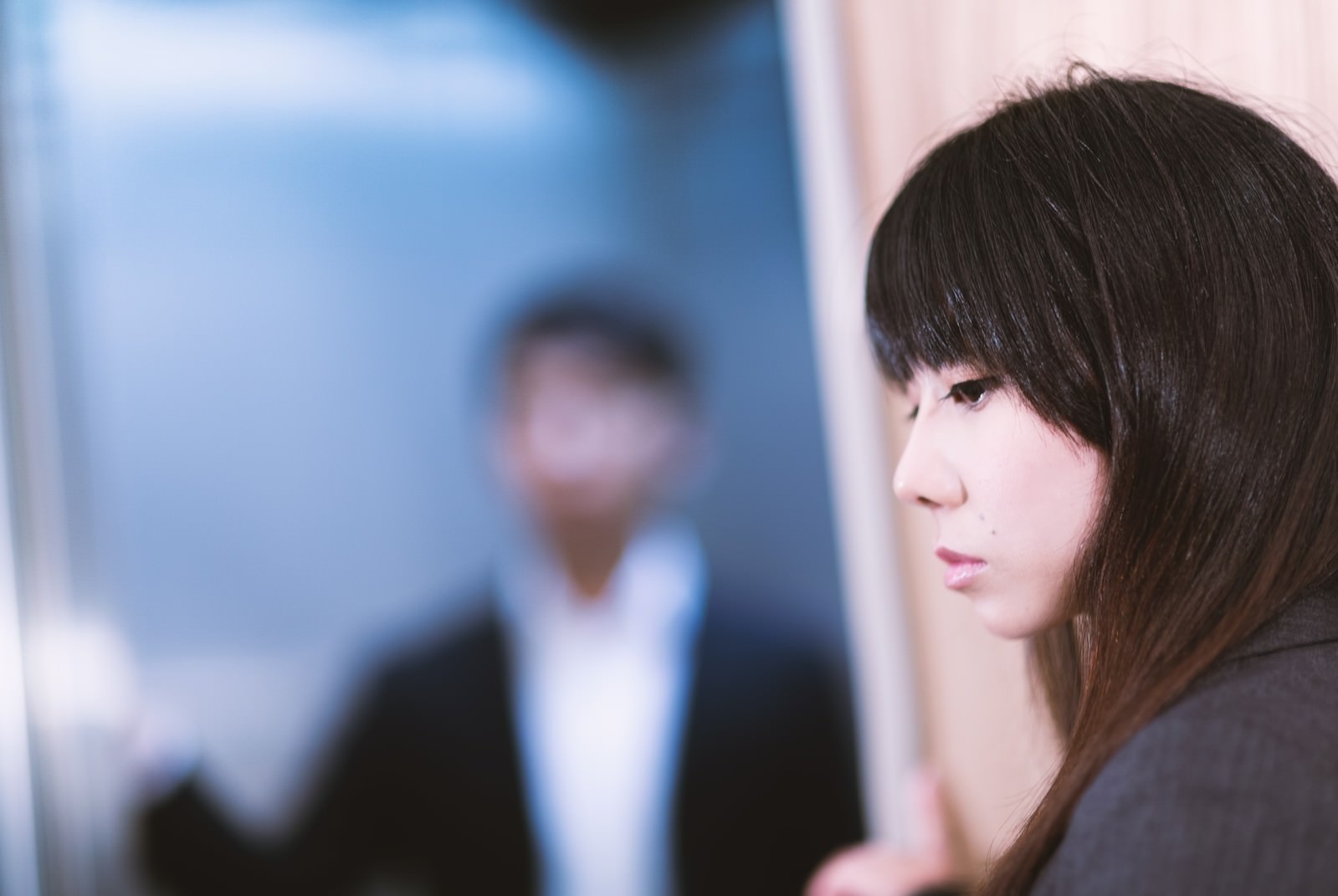 エレベーターで上司と鉢合わせし顔をそらす女性社員［モデル：Lala］