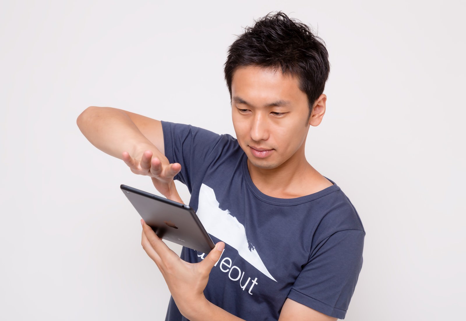 iPad miniをスワイプする男性が画面を操作している［モデル：大川竜弥］