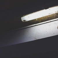 薄汚れた街灯の電気部分と配線、錆びた支持金具の写真