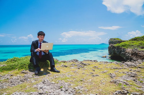 南国の海でも更新作業を怠らない意識の高いスーツ姿のブロガー