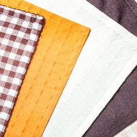 茶色やオレンジなど5色が斜めに重なるランチョンマットの写真