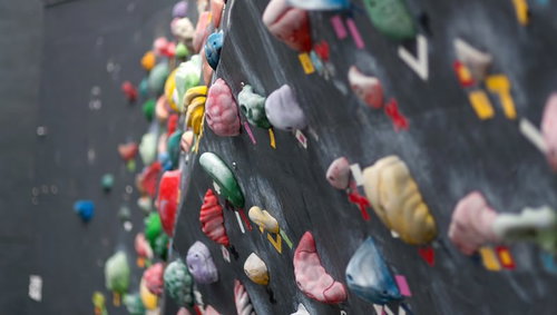 カラフルなホールドが並ぶボルダリングの壁