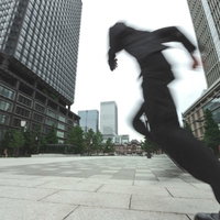 都市部を全力疾走するビジネスマン、高層ビル群での緊急対応の写真