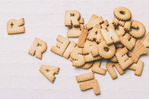 白い布の上に散らばるアルファベット型の焼き菓子クッキー