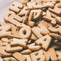 白い丸皿にアルファベットや数字の形のクッキーが山盛りの写真