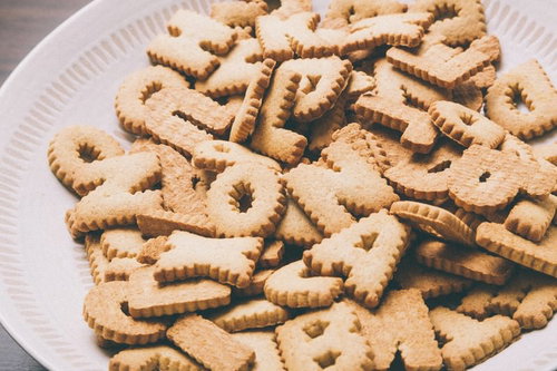 白い丸皿にアルファベットや数字の形のクッキーが山盛り