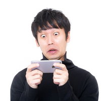 ぎょえー！スマホで衝撃映像を見てびっくり仰天する男性の写真