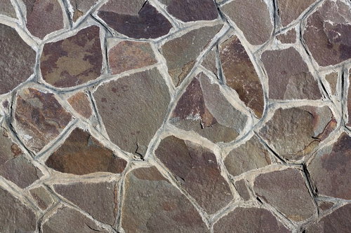 不規則に配置された自然石の乱雑な石壁のテクスチャ