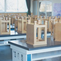 青と白の台に並ぶ木製の建物模型が並ぶ放課後の理科室の写真