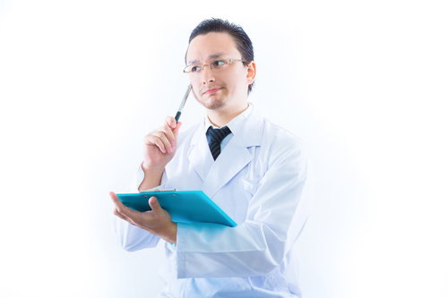 検査結果に悩む男性ドクター