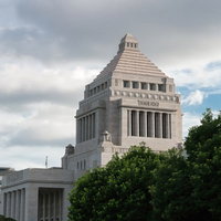 国会議事堂の側面外観と緑の木々の写真