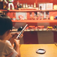お祭りの射的で遊ぶ子供の後ろ姿の写真