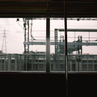 電車内の窓から見える駅ホームと鉄道施設の写真