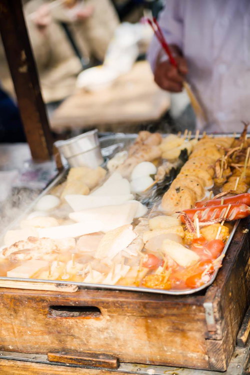 屋台に並ぶエビフライや揚げ物の串