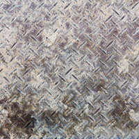 斜め模様の凸凹に錆や汚れが付いた鉄の床板のテクスチャーの写真