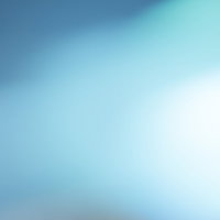 中央から右上に光が広がる青系グラデーションのぼけた抽象写真の写真