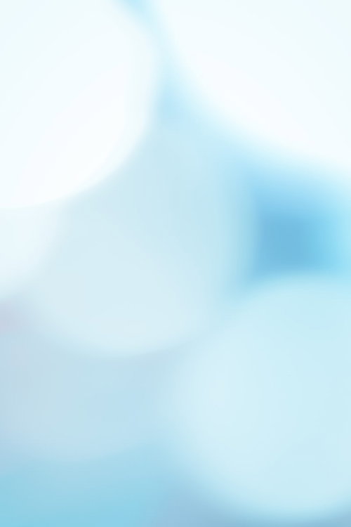 ぼけた三角形の物体が中央に写る明るい青系の抽象写真
