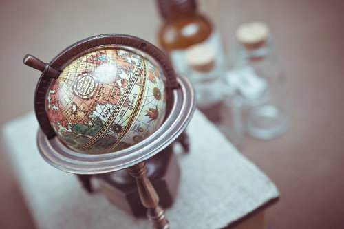 茶色と青緑で描かれた木製台座の小型の地球儀