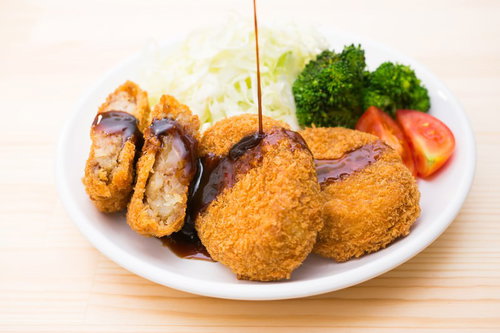 食卓のコロッケにかけるソース、白い皿に盛り付けた揚げ物料理