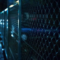 夜の金網フェンスとぼけた光の写真