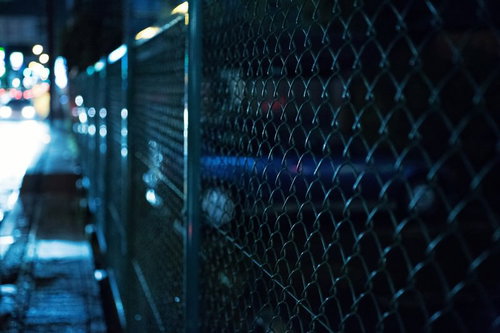 夜の金網フェンスとぼけた光