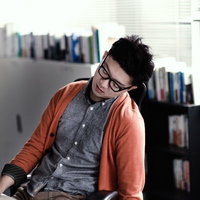 デスクで寝落ちする疲れた男性デザイナーの残業風景の写真