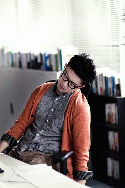 デスクで寝落ちする疲れた男性デザイナーの残業風景