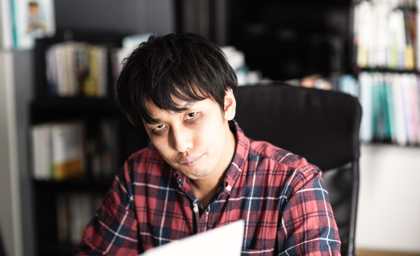 書類を持ち疲れた顔で前を見る男性［モデル：大川竜弥］