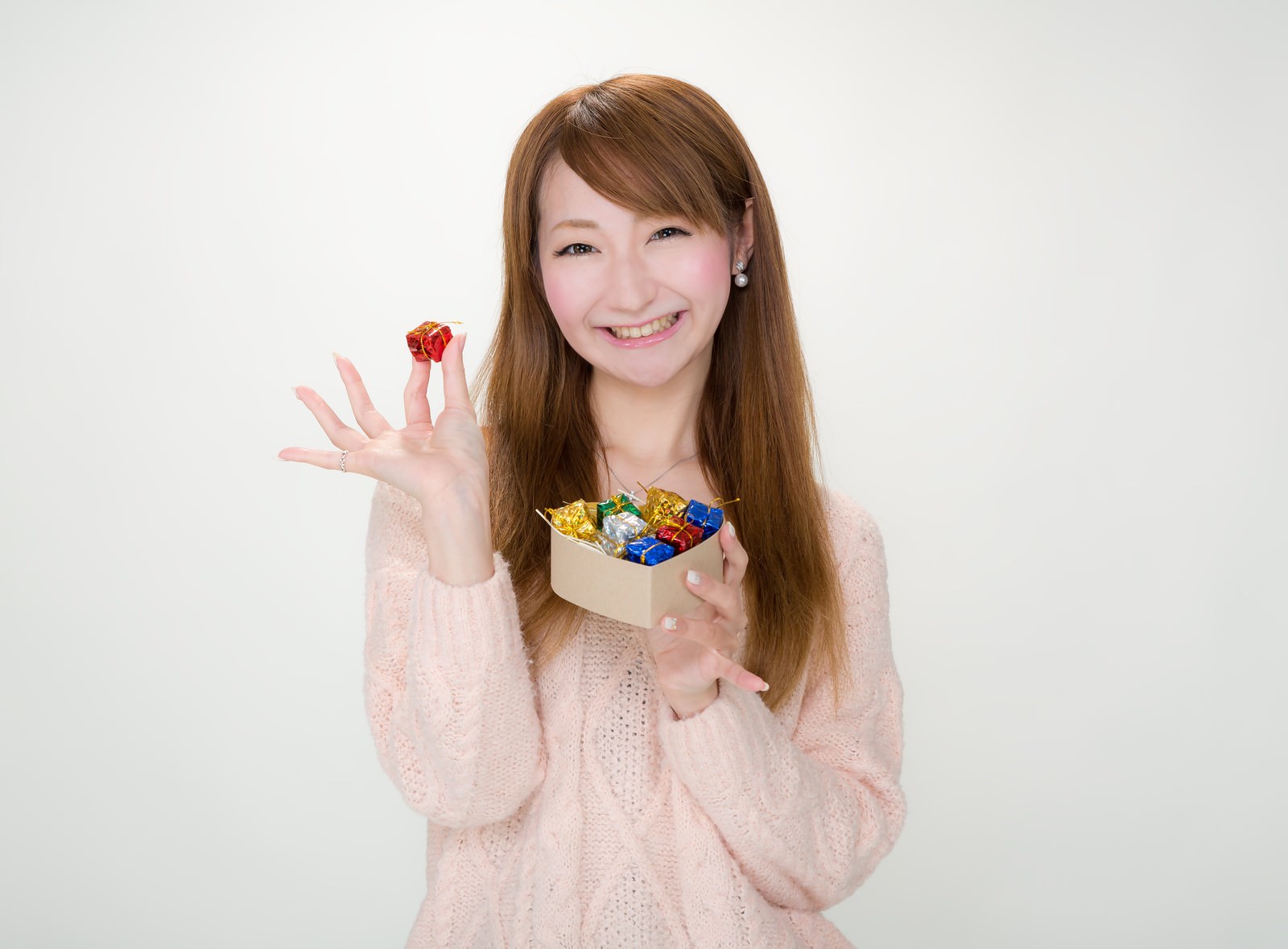 プレゼントボックスを持って笑顔の女性［モデル：to-ko］