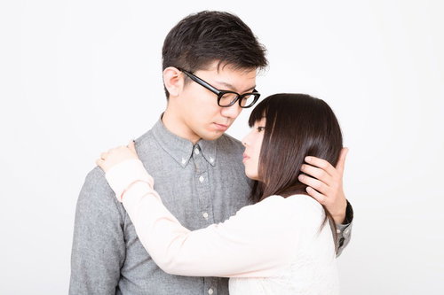 向かい合って抱き合う眼鏡の彼氏と黒髪の彼女