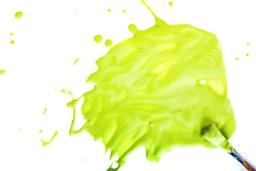 豪快に塗料を飛び散らせる黄緑色の絵の具のアート表現
