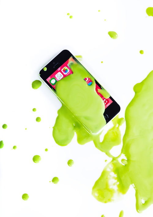 黄緑色の塗料が飛び散るスマートフォン｜破損アート