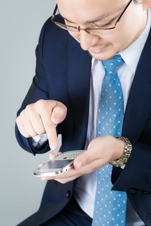 スマホを操作するスーツ姿のビジネスマン
