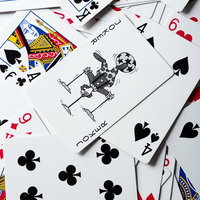 白い面に散らばったトランプとジョーカーの写真