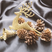 トナカイを型取ったクリスマスの飾りと松ぼっくりの写真