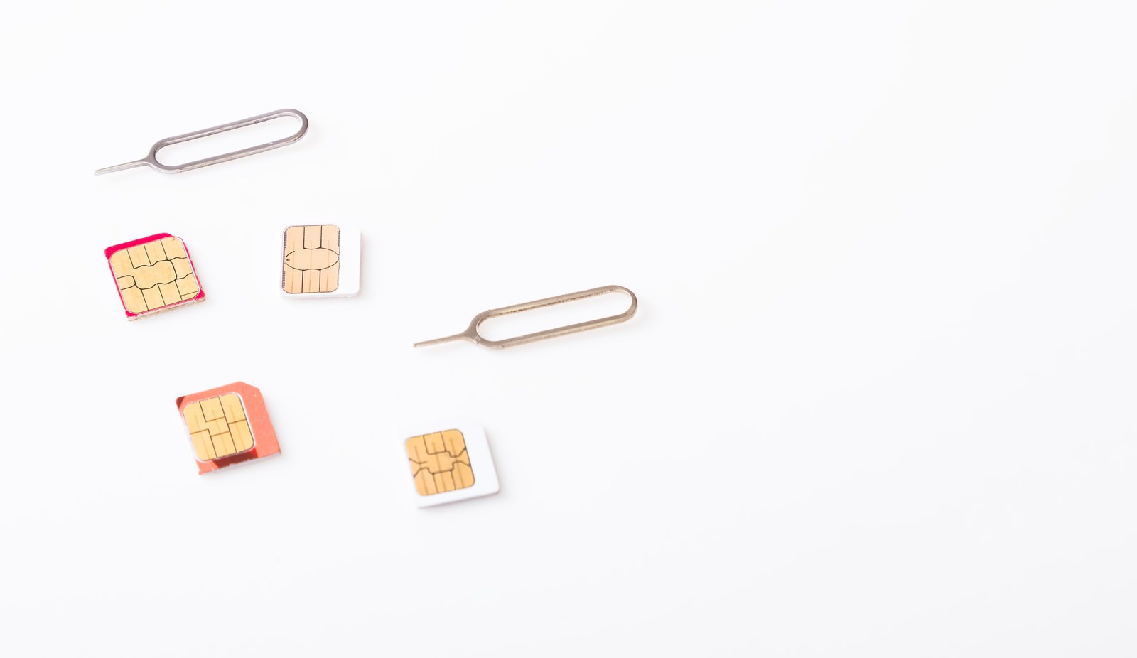 SIMカードとSIM取り出しピンが白い背景に並んでいる
