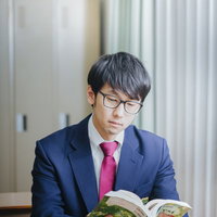 授業中堂々とマンガを読む眼鏡をかけた高校生の知能犯の写真