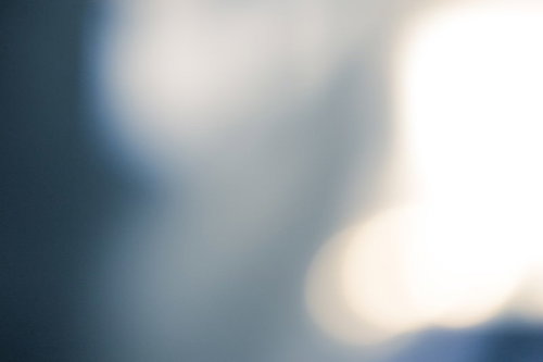 全体がぼけた青と白の形が重なる繁華街の光の抽象写真