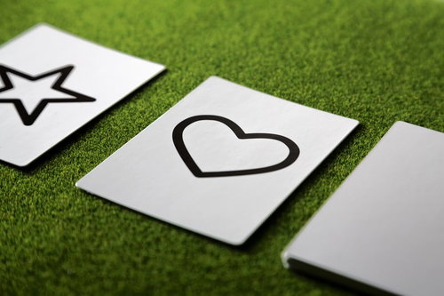 芝生に並ぶ星とハートが描かれた白いカード