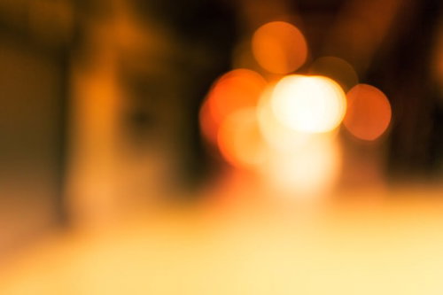 暗い中にオレンジや黄色の丸い光が重なるボケ写真