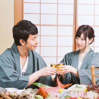 伊東温泉旅館で海の幸を肴に乾杯するカップルの写真