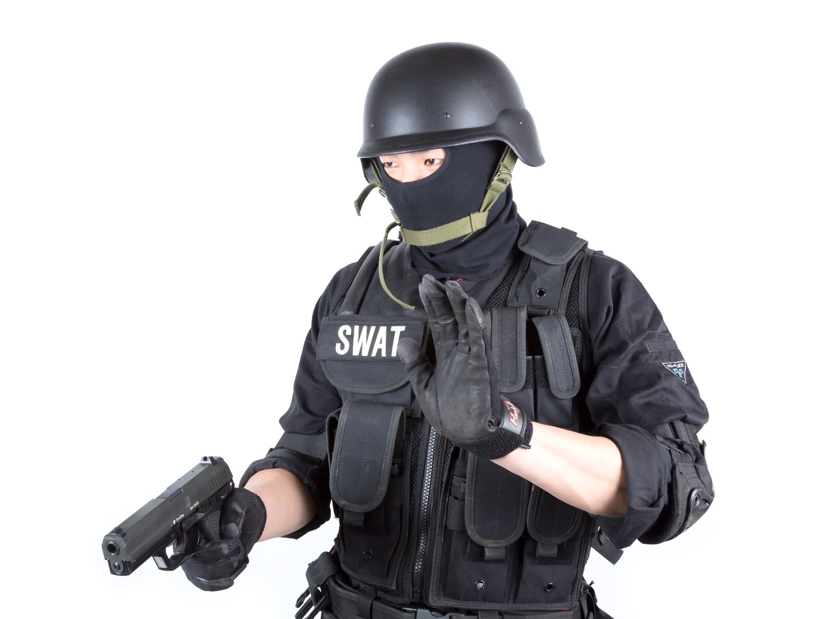 SWATの文字がある防弾ベストにヘルメットとマスクの隊員が拳銃を持っている［モデル：モデルリリース］