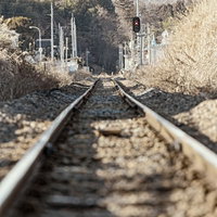 山が見える田舎の線路と赤い信号機の写真