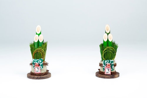 金色の飾りと鏡餅が付いた松の門松が2つ並ぶ正月飾り