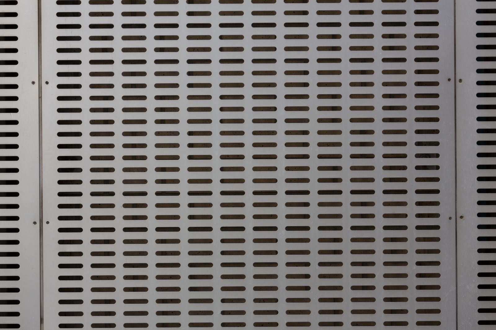 規則正しく配列された丸い穴が開いたグレーのメタルパネル