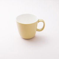 置かれた淡い黄色のマグカップの写真